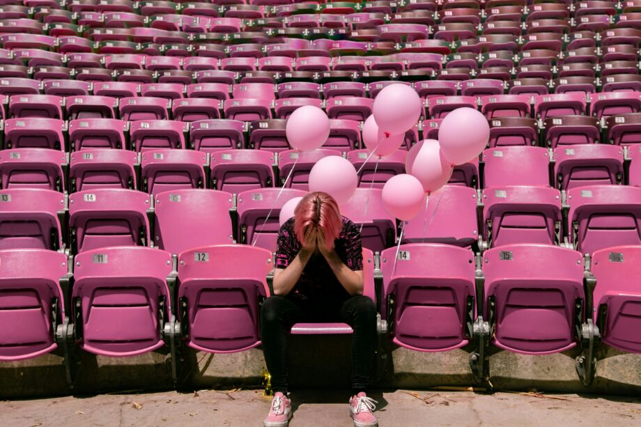 a woman having an existential crisis on pink bleachers